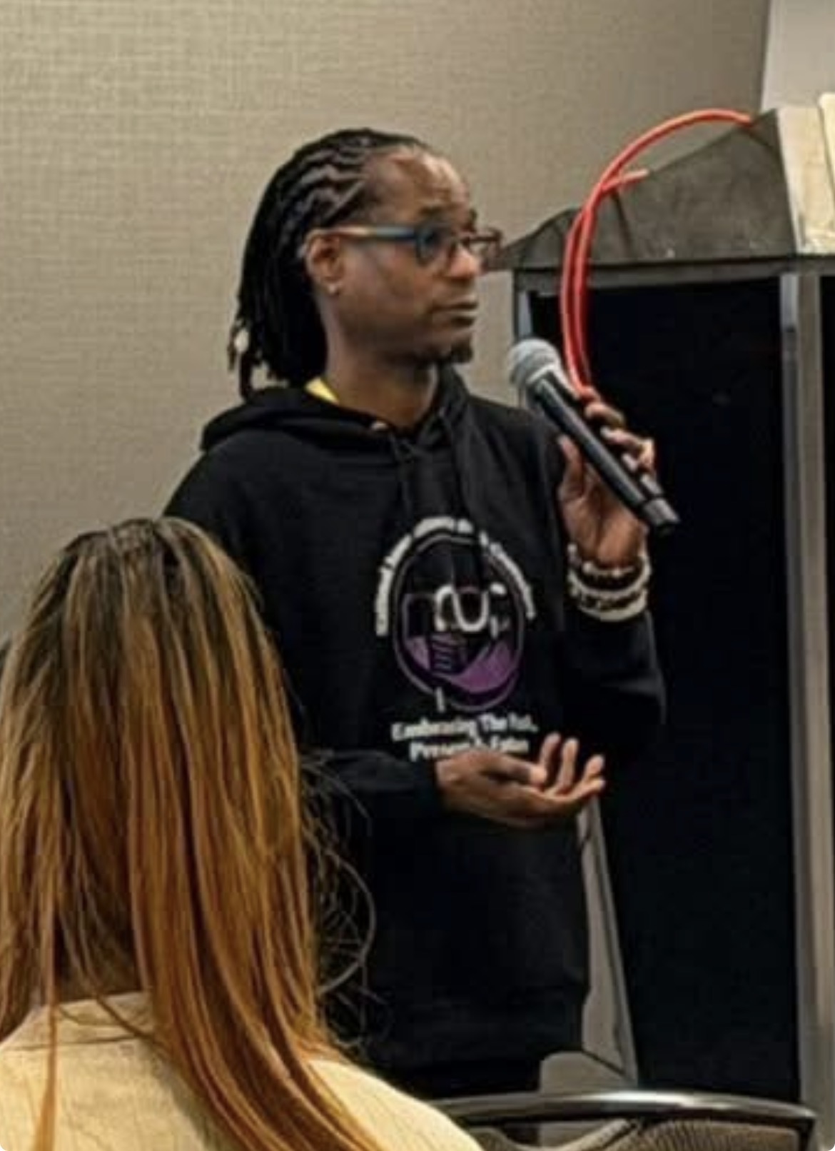 Dr. Nick speaking with a microphone during a professional presentation